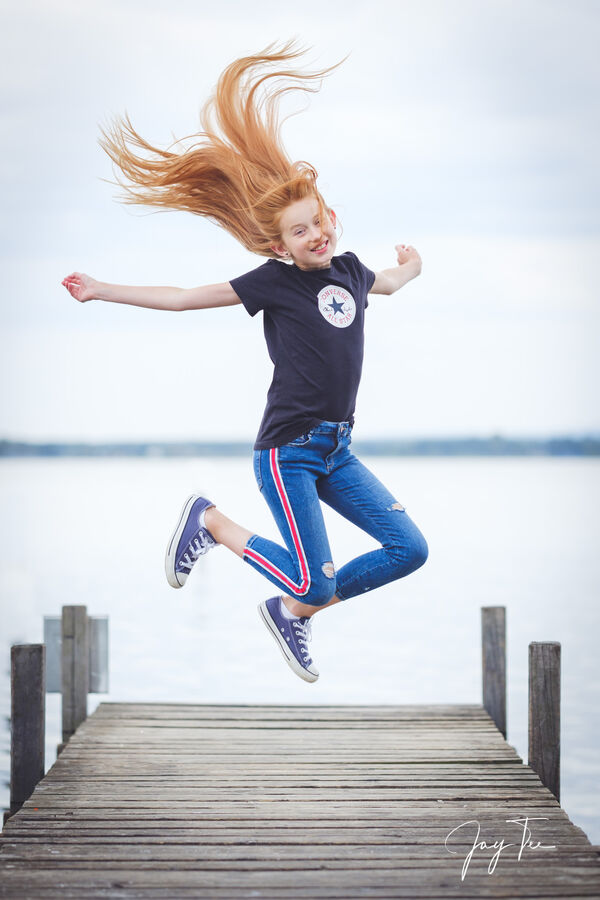 Girl with long red hairs jumps in the air.